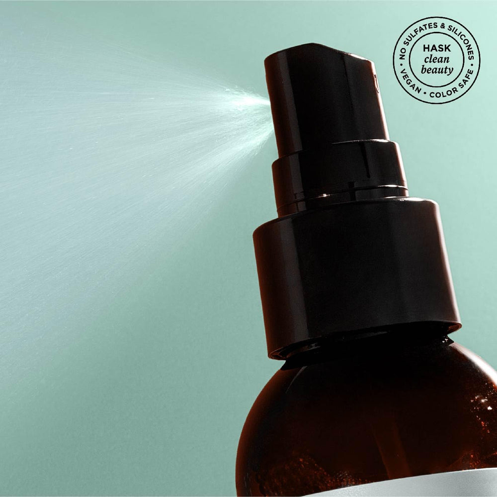 Hand holding HASK spray to show size and portability for travel and gym use