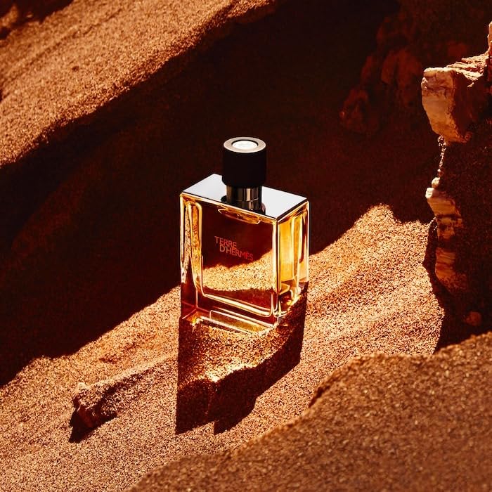 Hermès Terre d'Hermès 75 ml next to everyday objects showing compact travel-friendly size