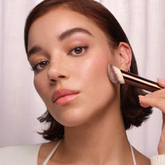 Hourglass brush beside Ambient Soft Glow Foundation showing size comparison
