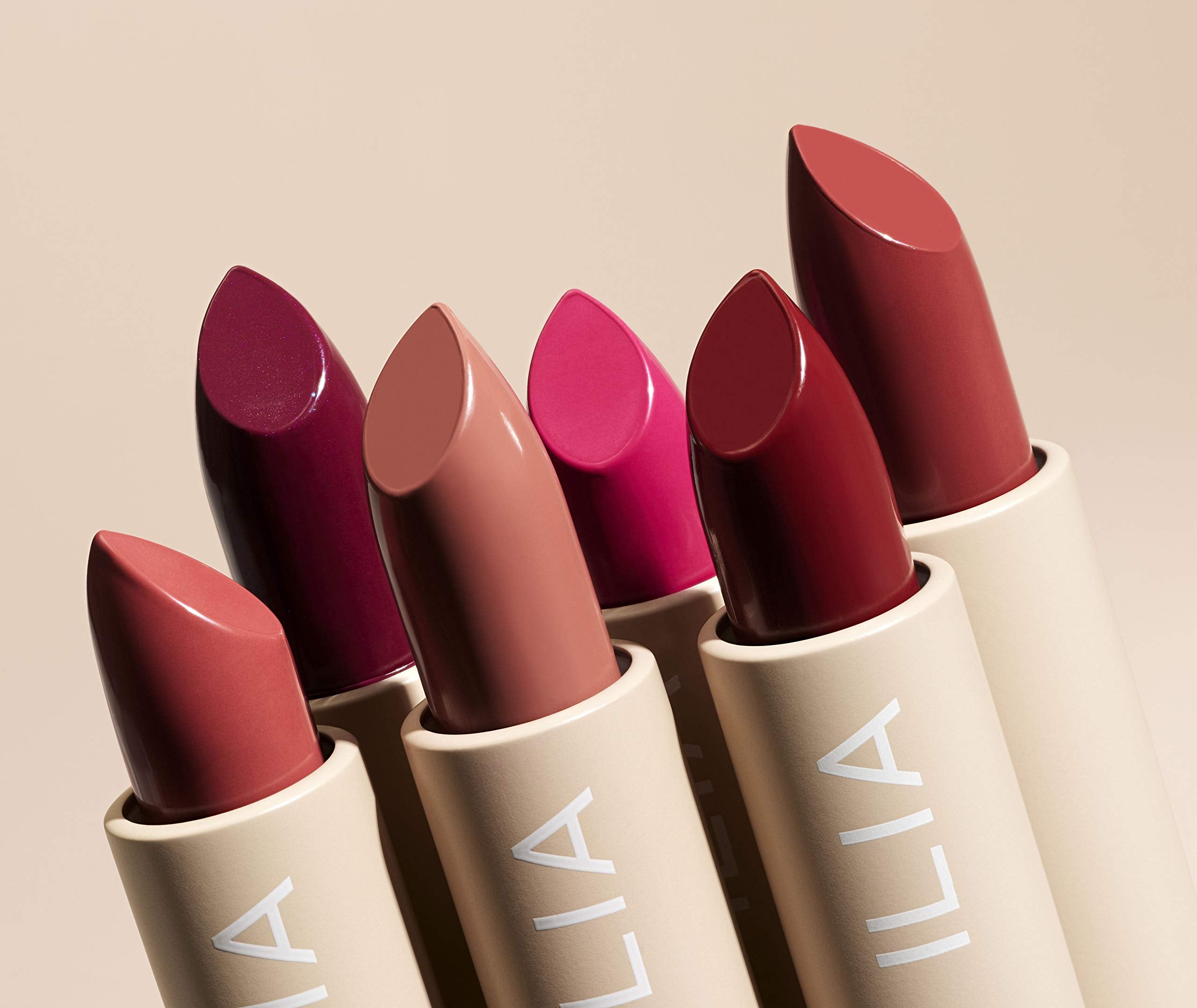 ILIA Tango next to a standard lipstick for scale demonstrating compact size