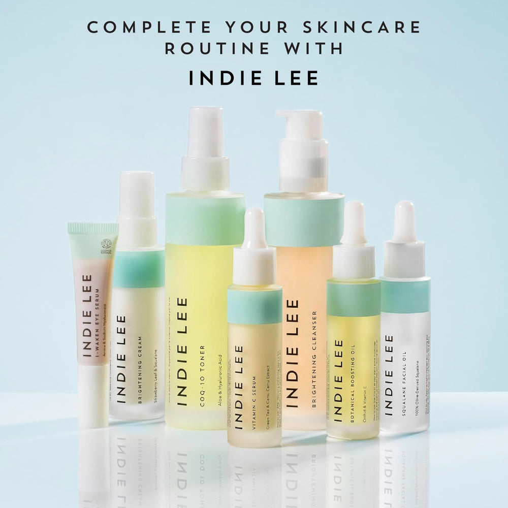 Indie Lee 125ml bottle beside common items to show travel-friendly size