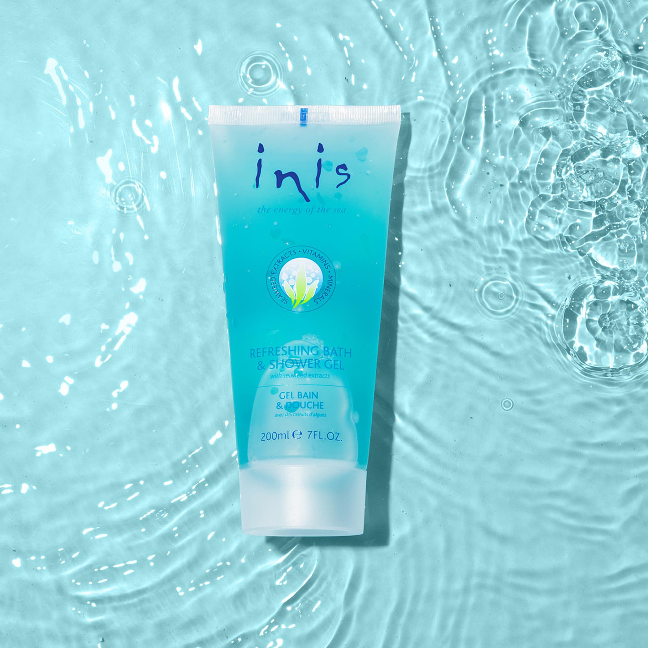 Inis bottle beside toiletries showing compact 7 fl oz travel-friendly size