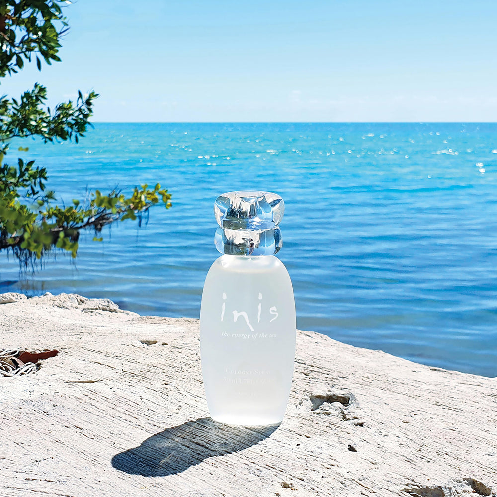 Inis bottle held in hand showing 1 fl oz size and portable convenience benefit