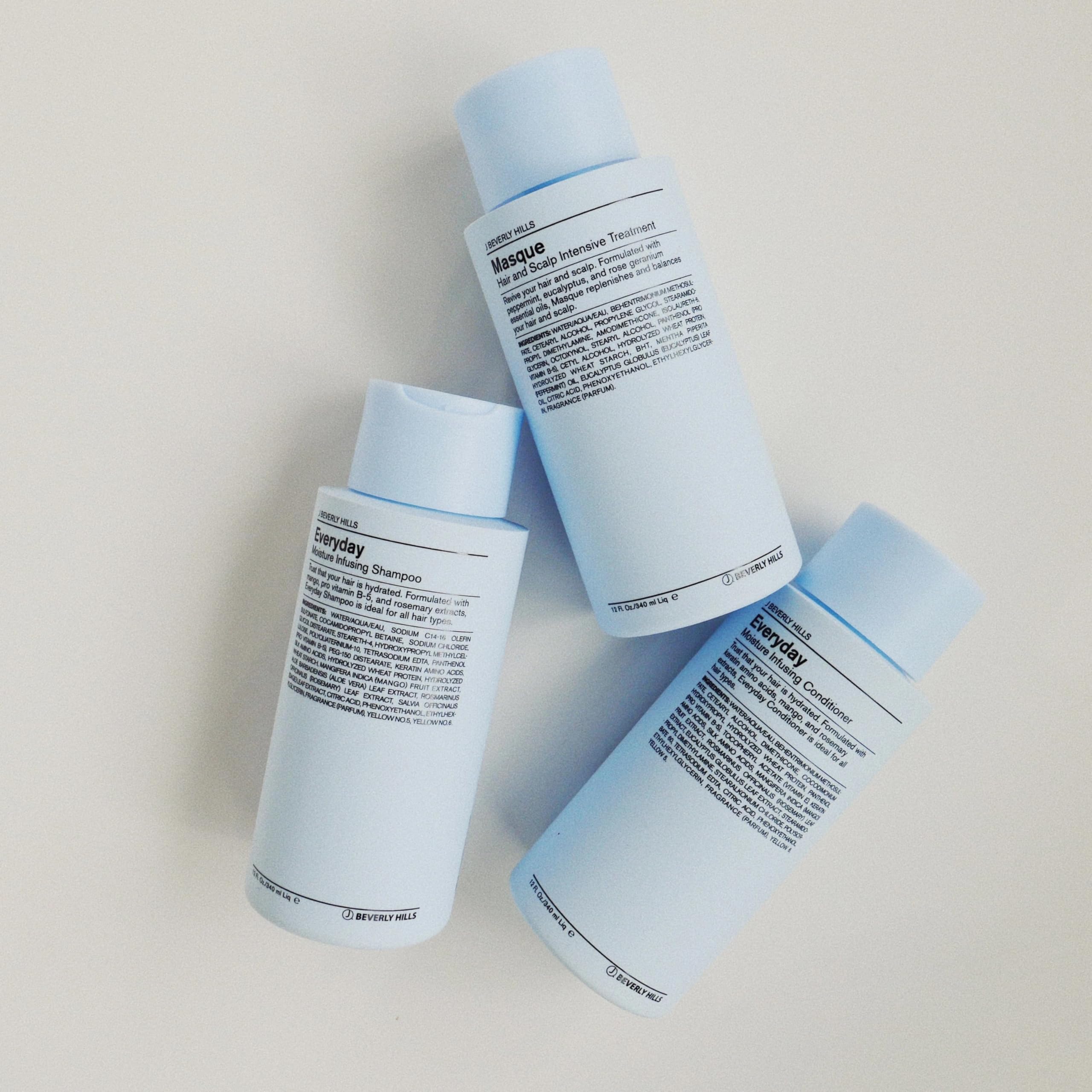 Hand holding J Beverly Hills 12 oz bottle showing size and travel-friendly benefit