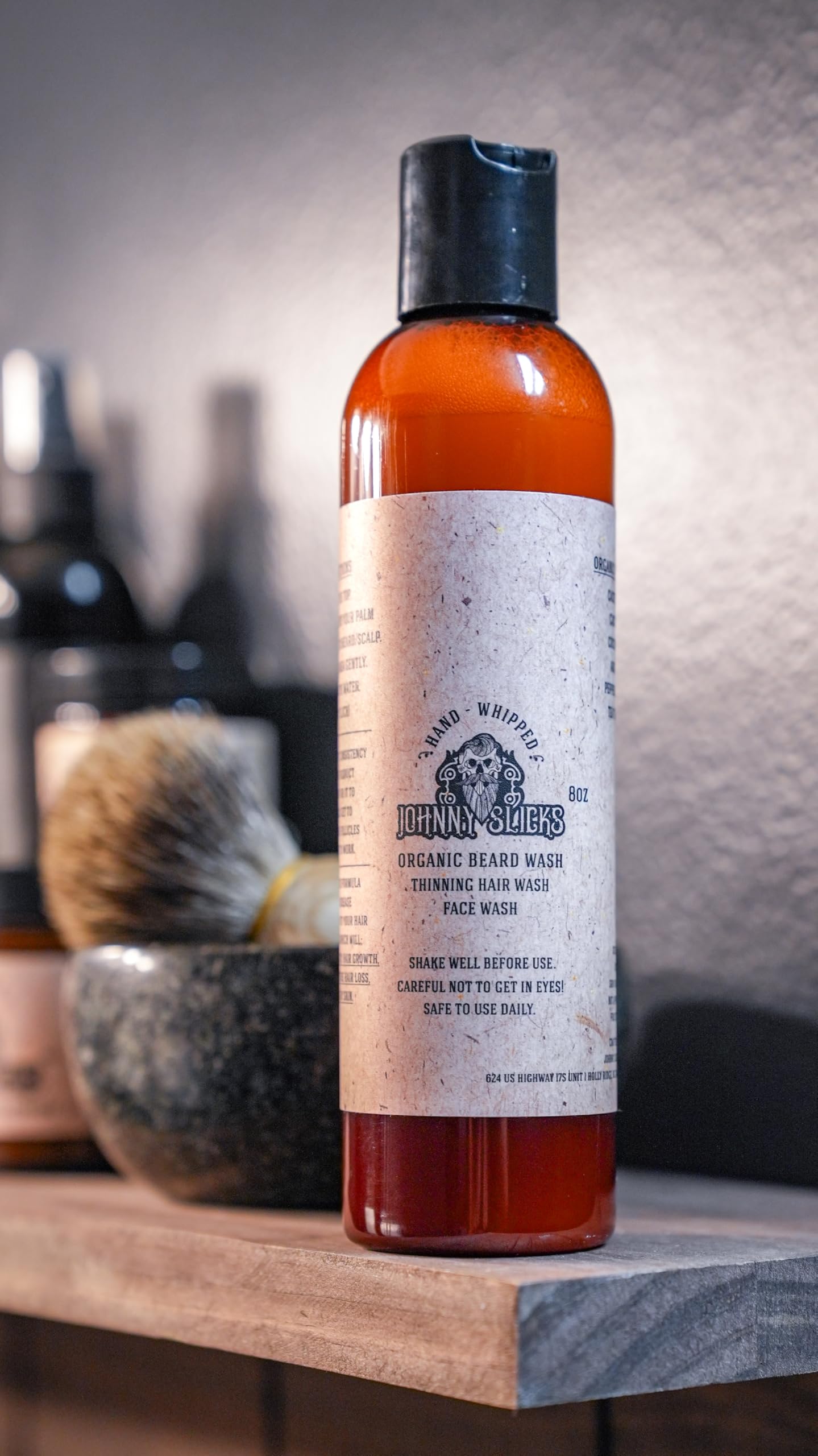 Johnny Slicks bottle in hand showing 8 oz scale for travel-friendly benefit
