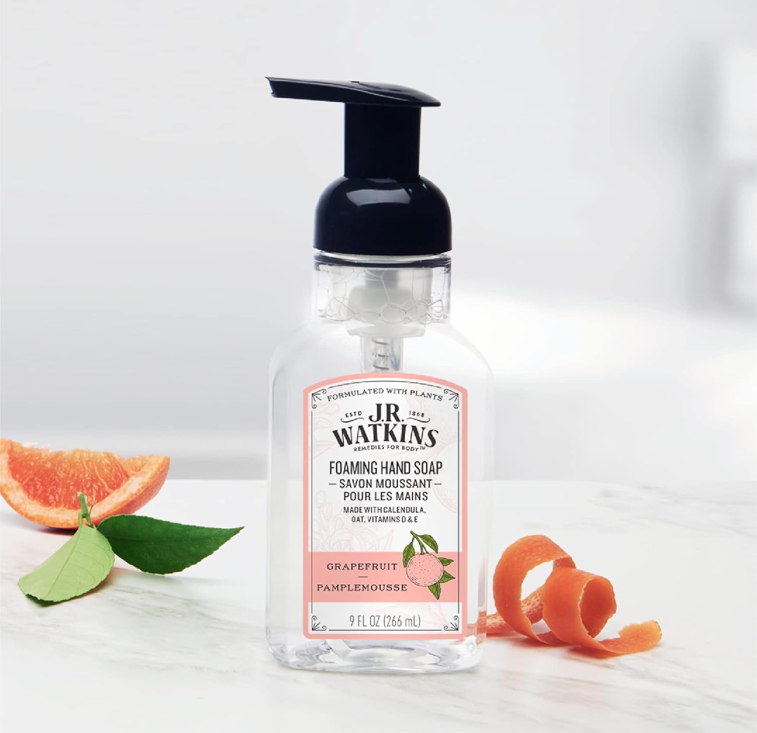 J.R. Watkins grapefruit bottles on a kitchen sink creating an uplifting, fresh handwashing station