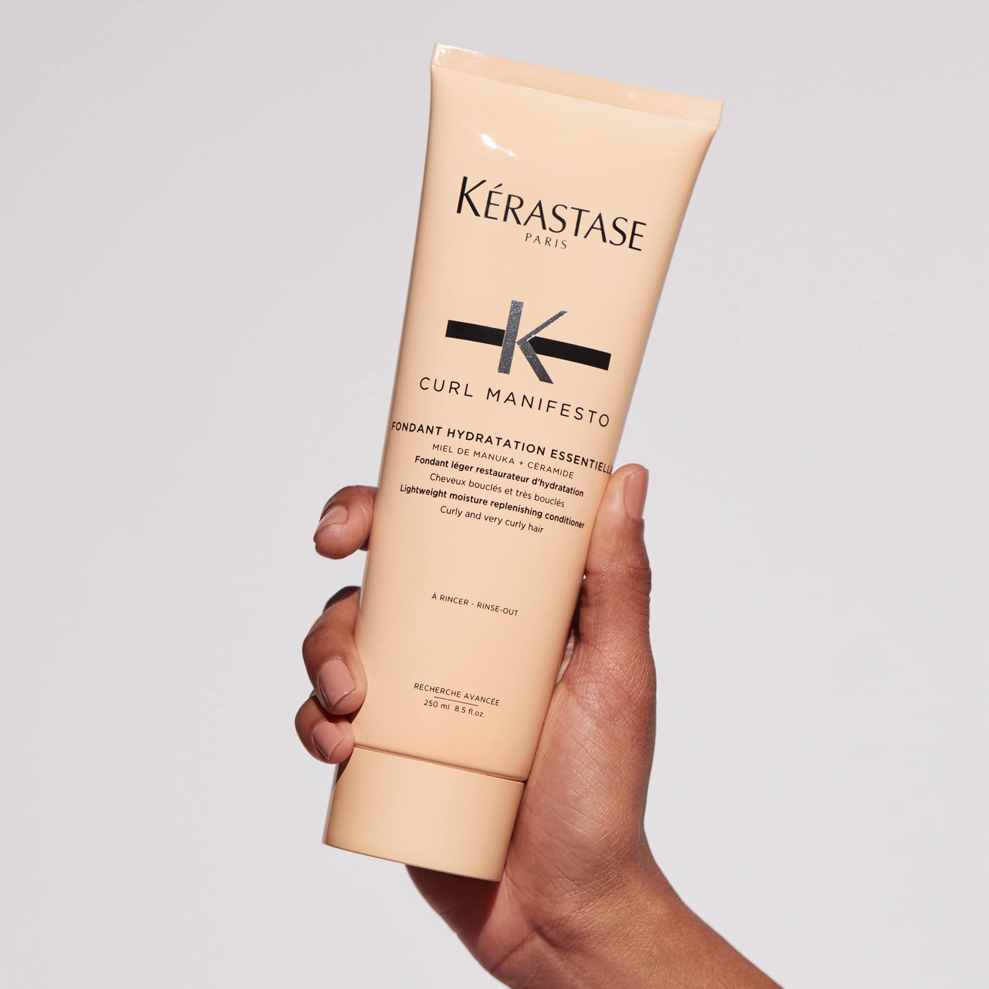 KÉRASTASE bottle next to common items showing 8.5 fl oz scale