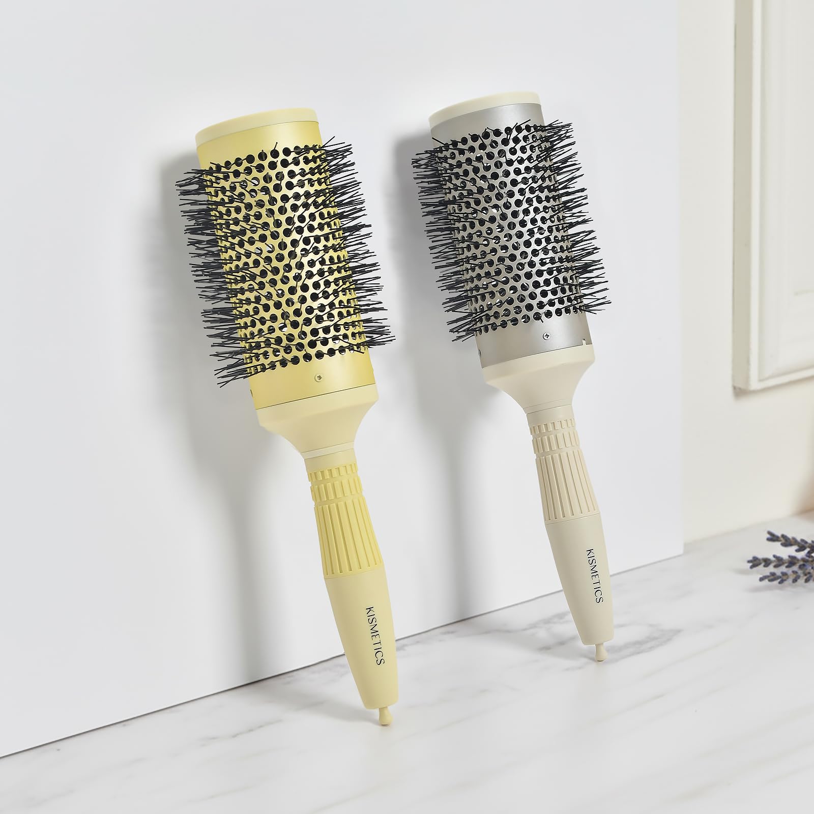 KISMETICS brush next to hand to show 2.1" barrel size and styling scale