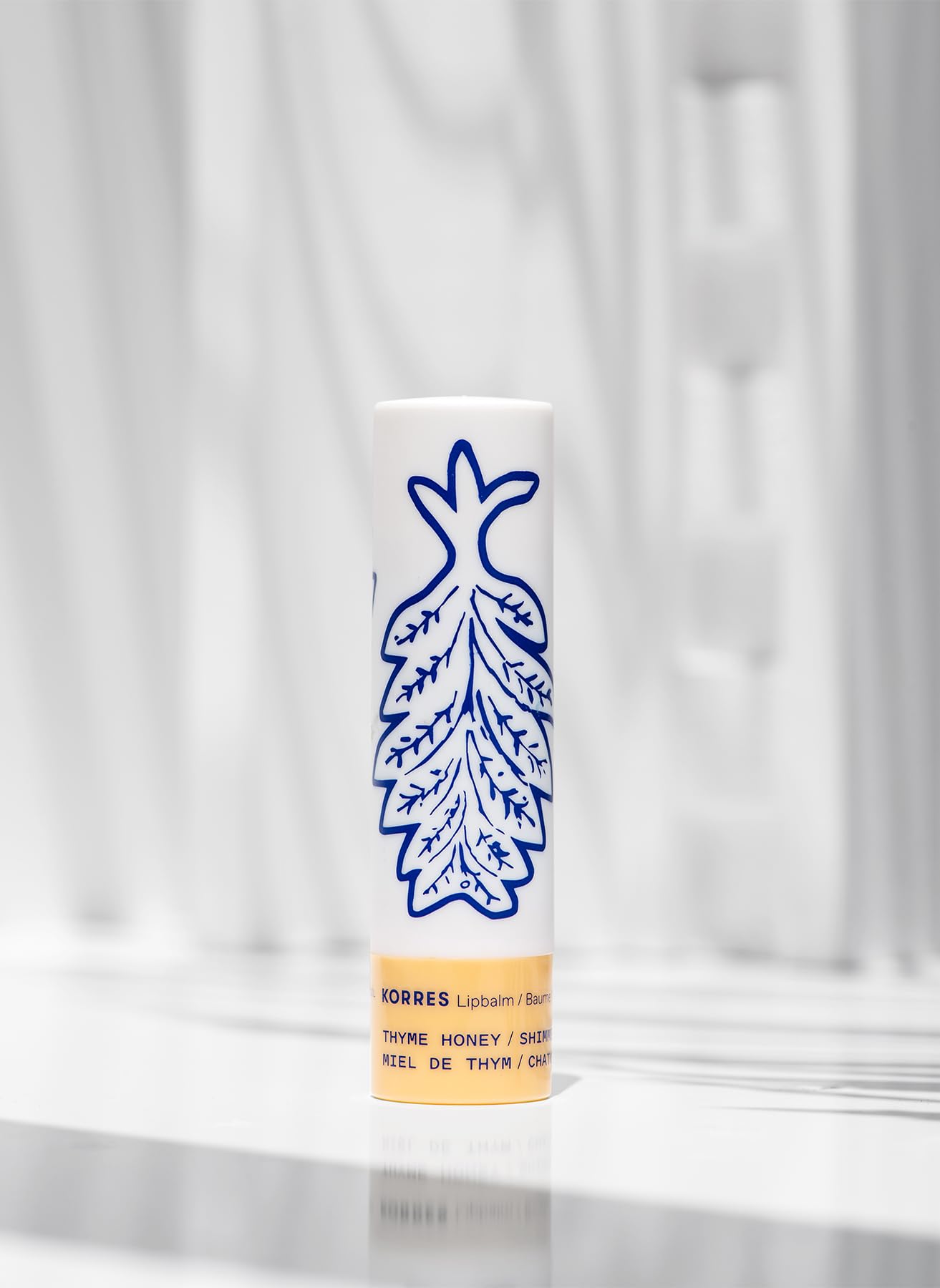 KORRES lip butter applied on lips in lifestyle setting for subtle golden glow