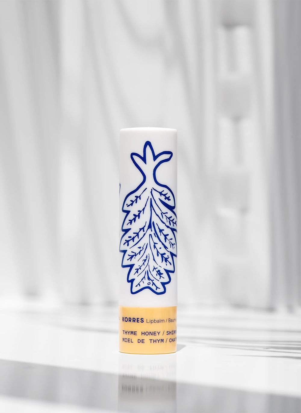 KORRES lip butter applied on lips in lifestyle setting for subtle golden glow