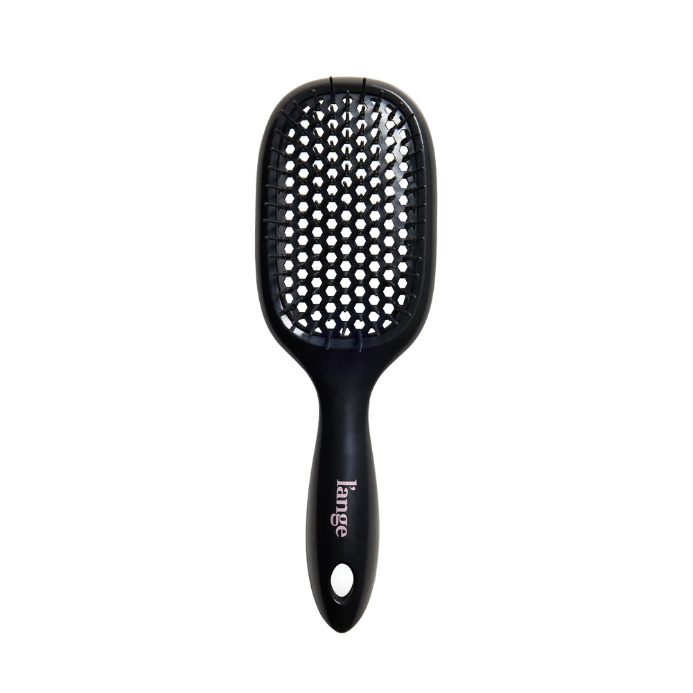 L'ANGE HAIR brush held in hand to show compact size and comfortable control
