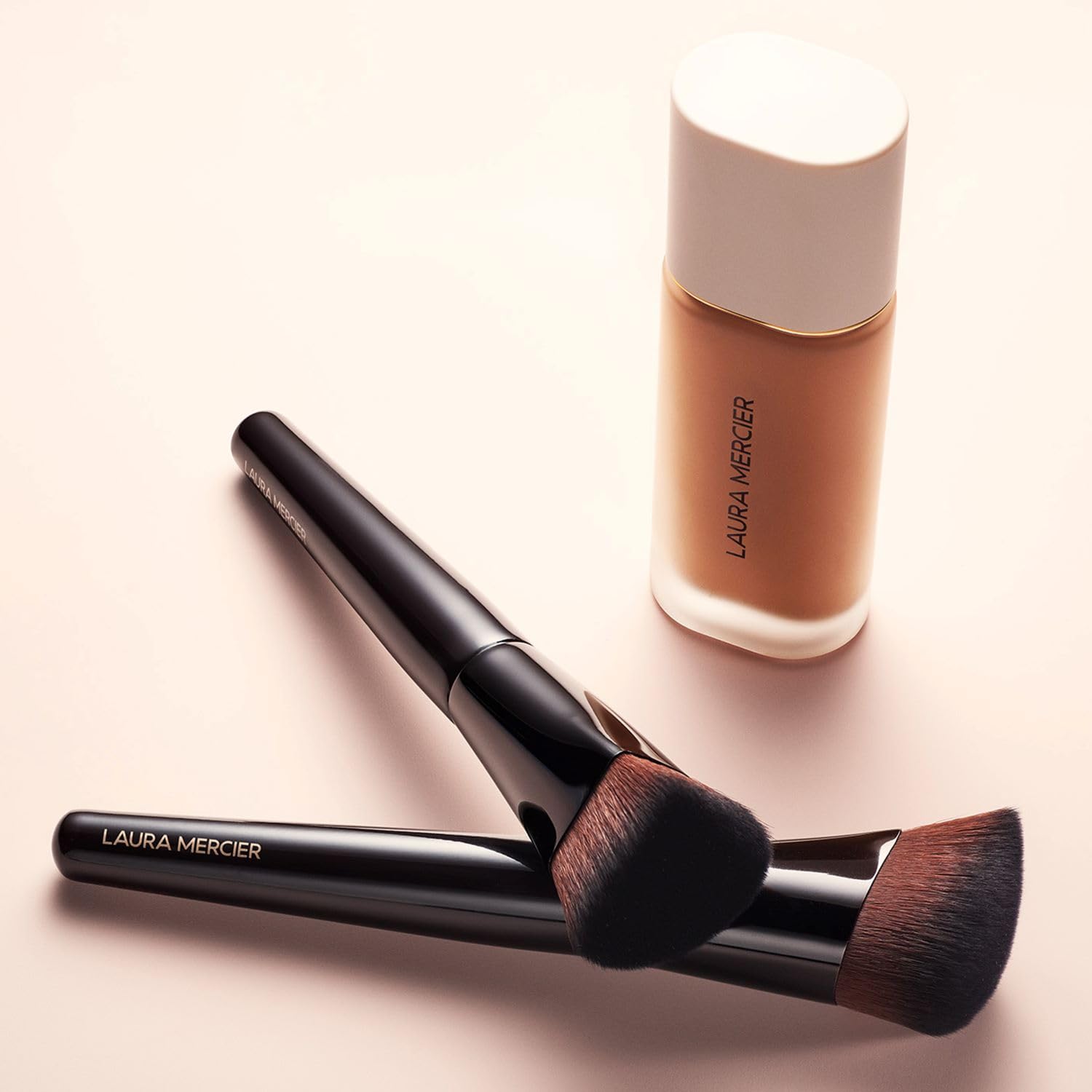 Laura Mercier brush applying foundation to cheek for natural, even coverage