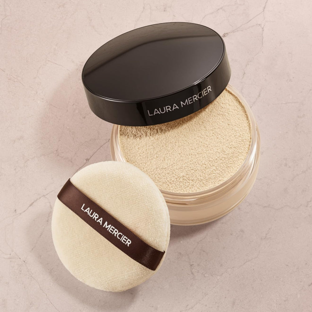 Laura Mercier velour puff held in hand to show 3.15" size for targeted coverage