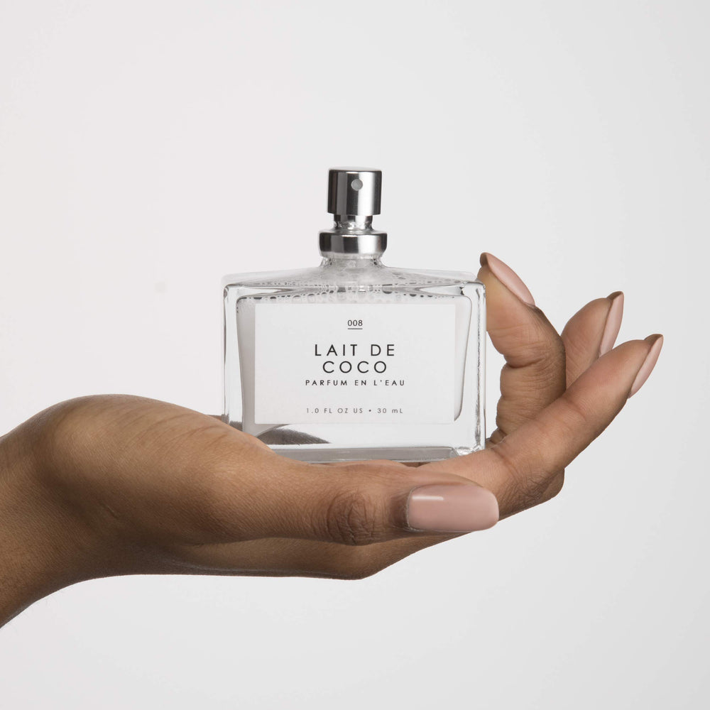 Le Monde Gourmand next to a coin showing the 30 ml bottle scale for travel convenience