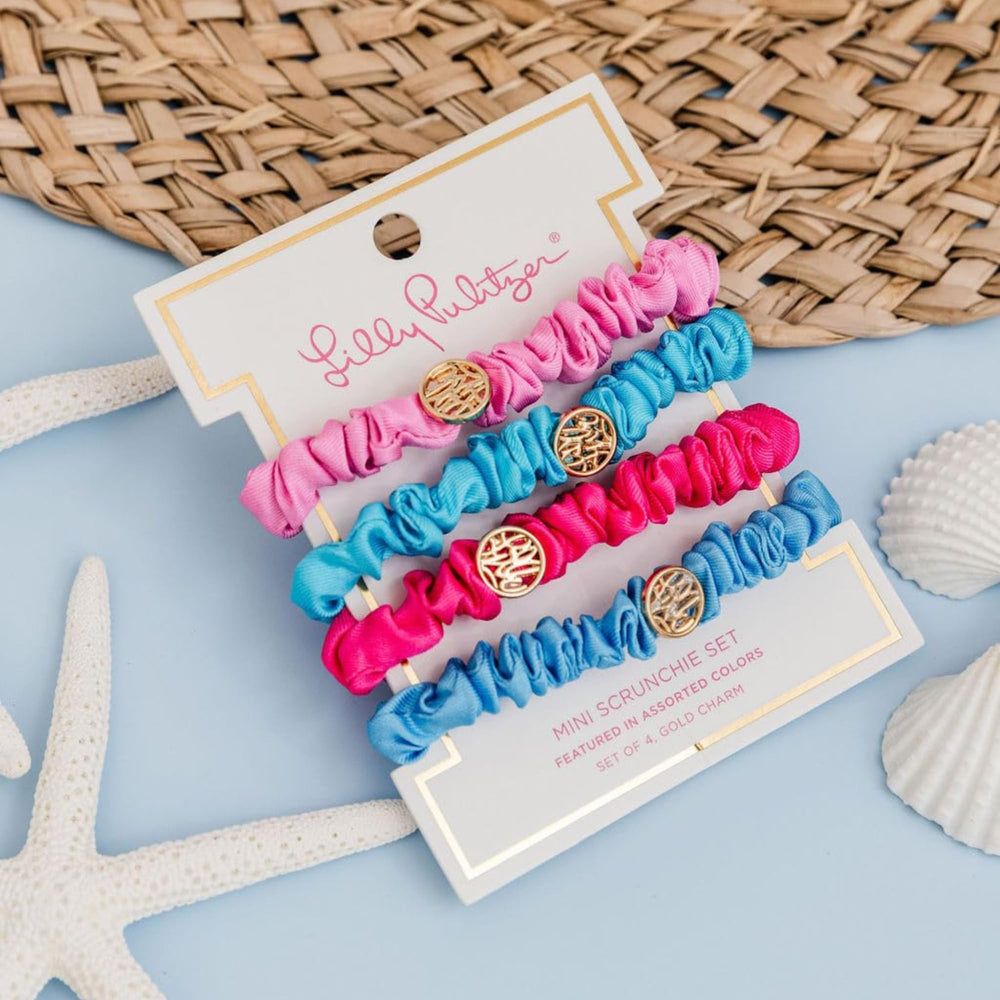 Lilly Pulitzer scrunchie next to hand for scale illustrating compact, travel-friendly size