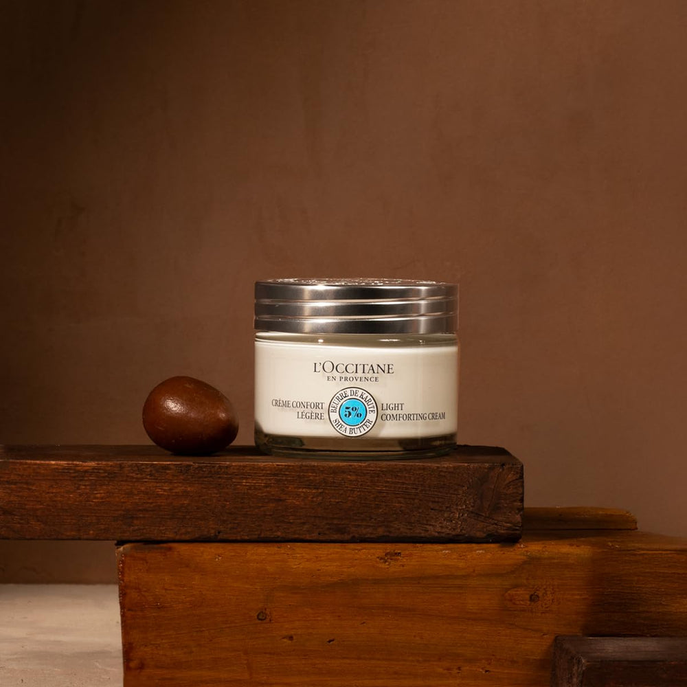 L'OCCITANE cream held in hand to show 1.69 fl oz scale and travel-friendly size