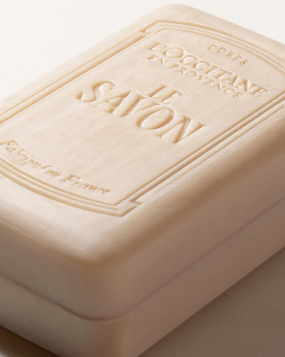 L'OCCITANE shea milk soap next to common items showing 8.8 fl oz scale and value