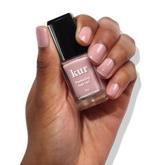 LONDONTOWN swatch on nail tip demonstrating the sheer Dusty Rose tint and natural-enhancing finish