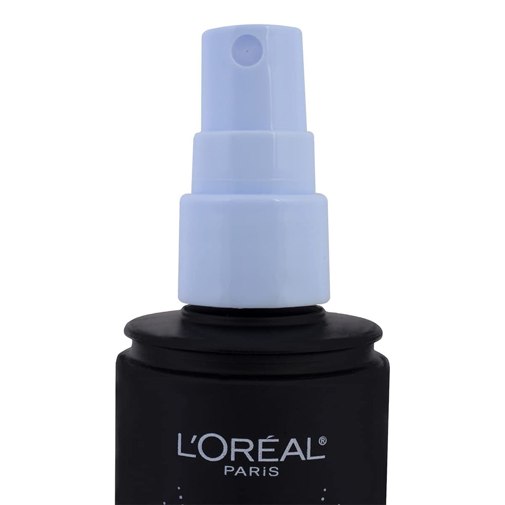 L'Oreal Paris bottle in hand showing 3.4 oz scale for travel-friendly use