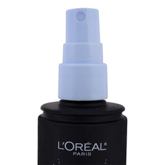 L'Oreal Paris bottle in hand showing 3.4 oz scale for travel-friendly use