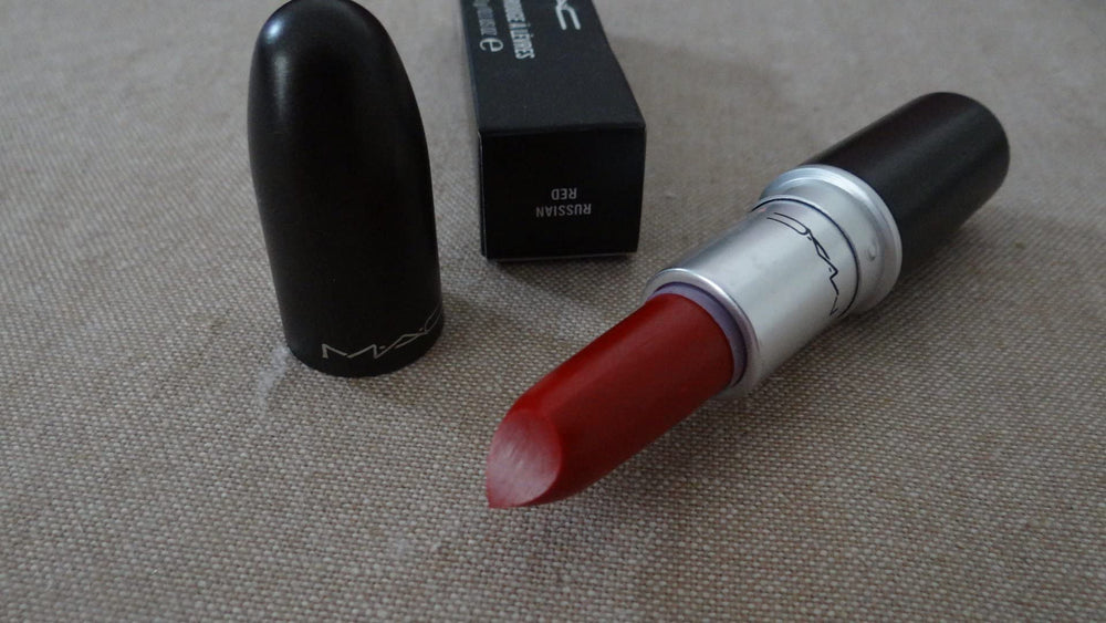 MAC Russian Red beside coin for scale indicating compact 0.1 oz size