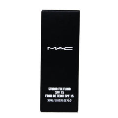 Hand holding M.A.C Studio Fix bottle to show size and scale for travel-friendly use