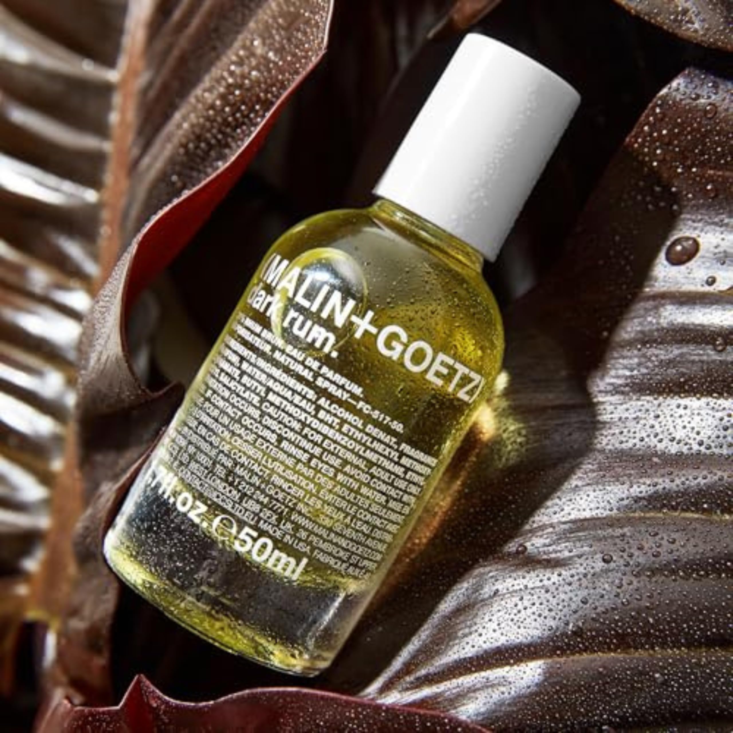 MALIN+GOETZ flatlay of bergamot, plum and anise representing scent notes