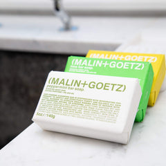 MALIN+GOETZ bar in shower setting demonstrating gentle foaming and hydrating benefit during use