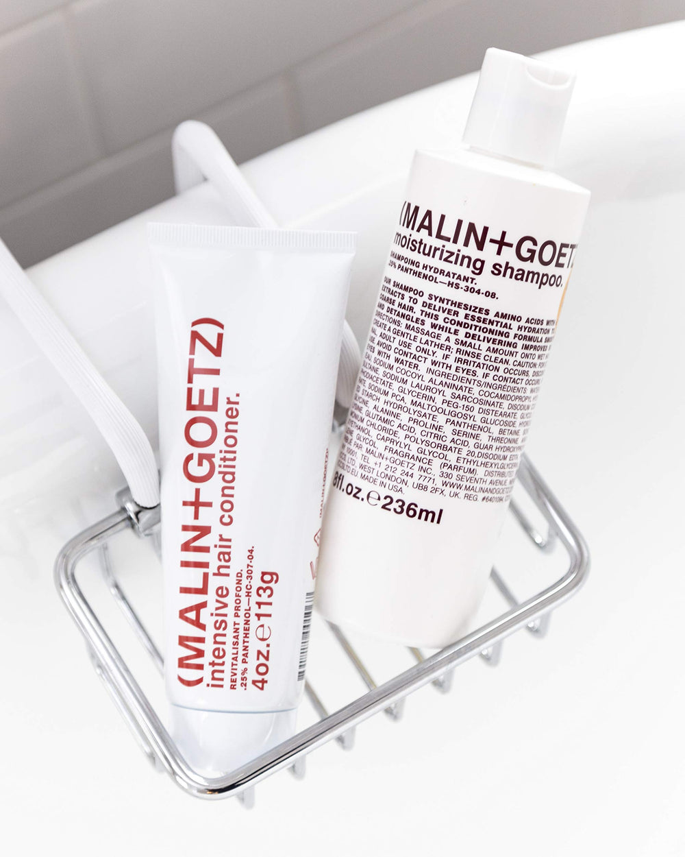 MALIN+GOETZ bottle next to measuring cup indicating 8 fl oz size and travel convenience