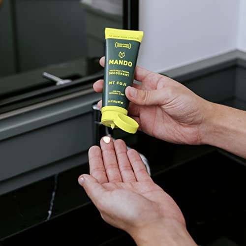Mando tube held in hand to show 3 oz travel-friendly size and portability
