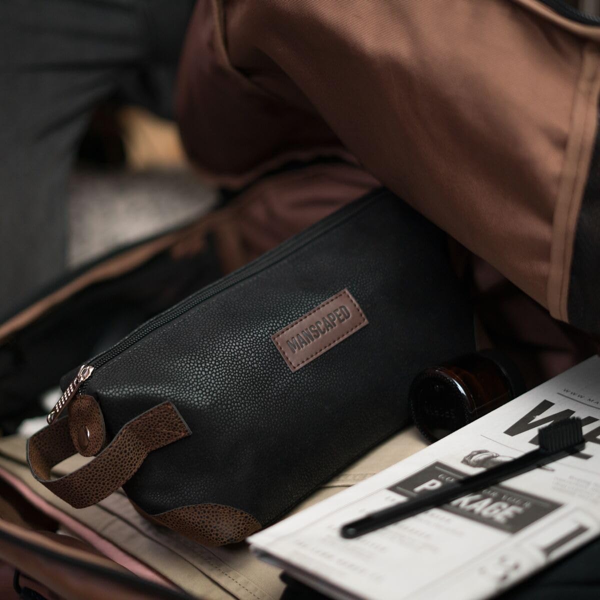 MANSCAPED bag beside common toiletries for size comparison — compact travel fit
