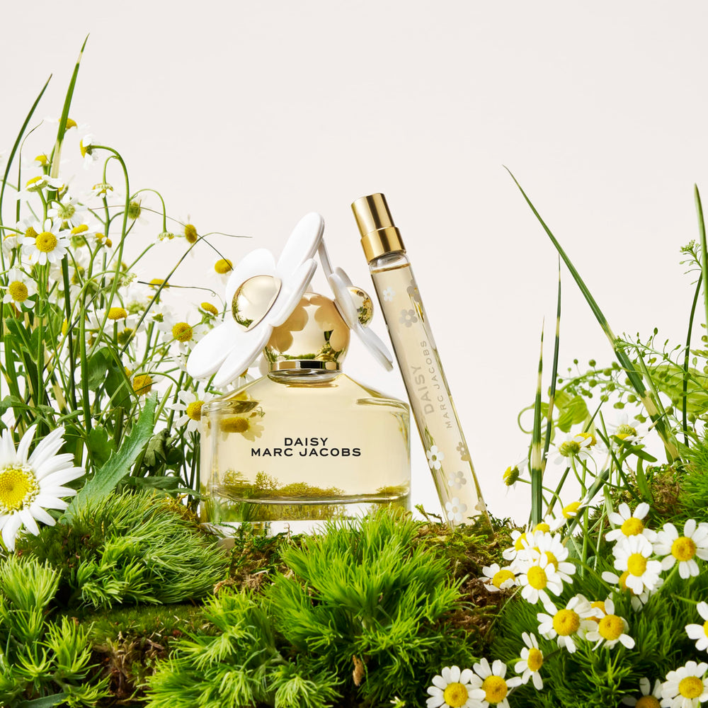 Marc Jacobs Daisy bottle on a travel vanity evoking carefree, portable freshness