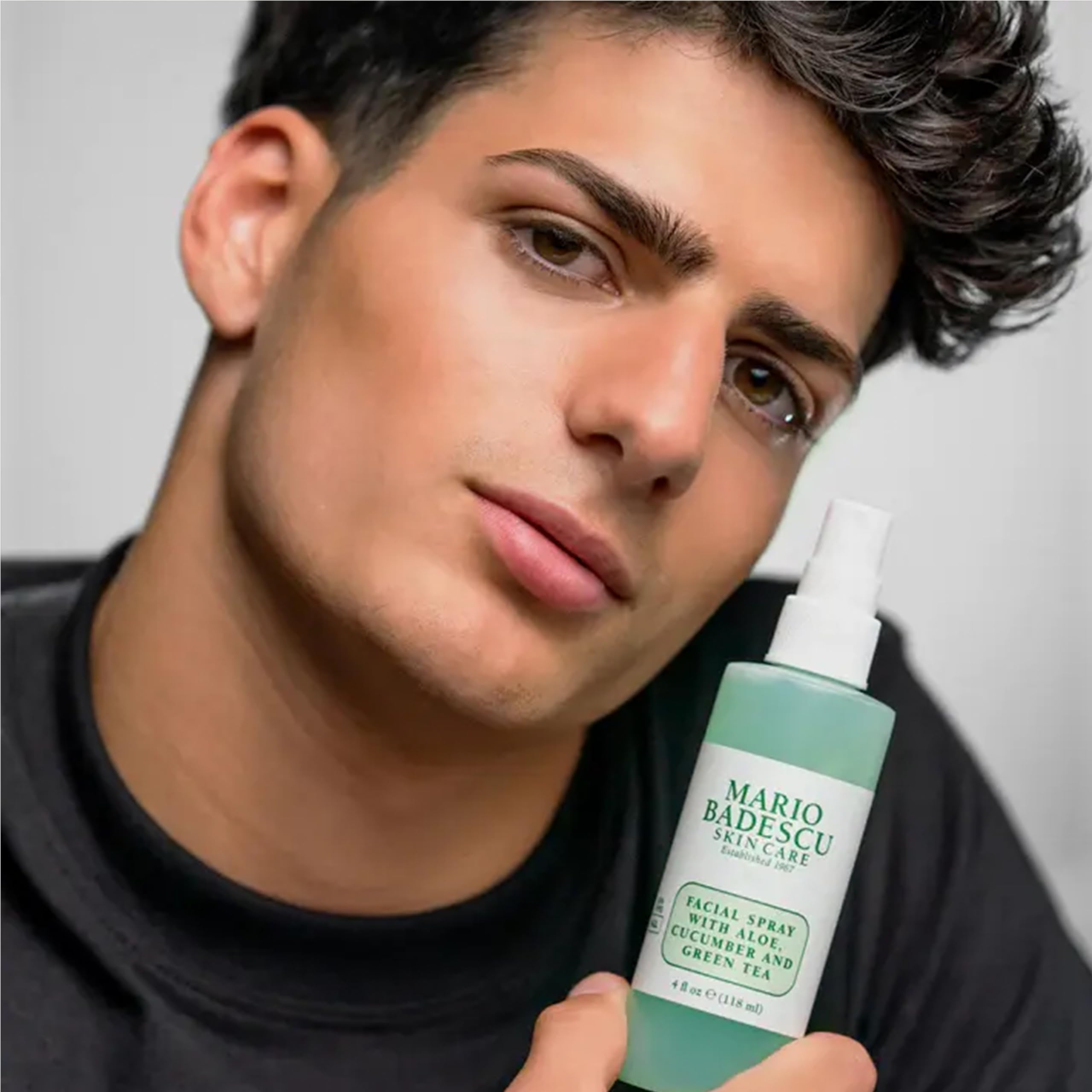 Mario Badescu bottle next to hand showing true size and travel readiness