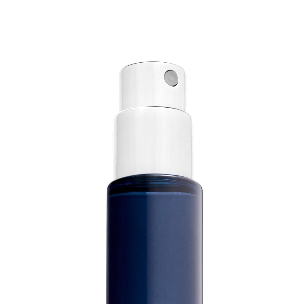 Michael Malul travel spray next to passport showing 10ml size ideal for carry-on