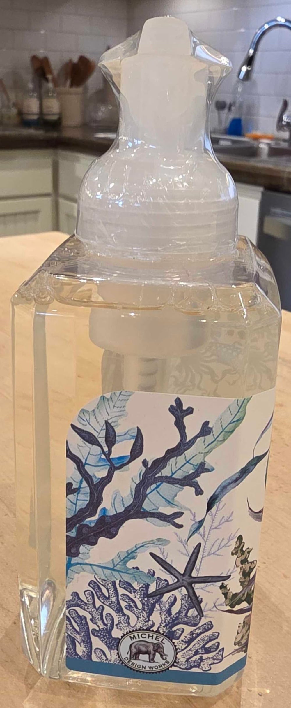 Michel Design Works bottle beside towel showing size and stylish sink display benefit