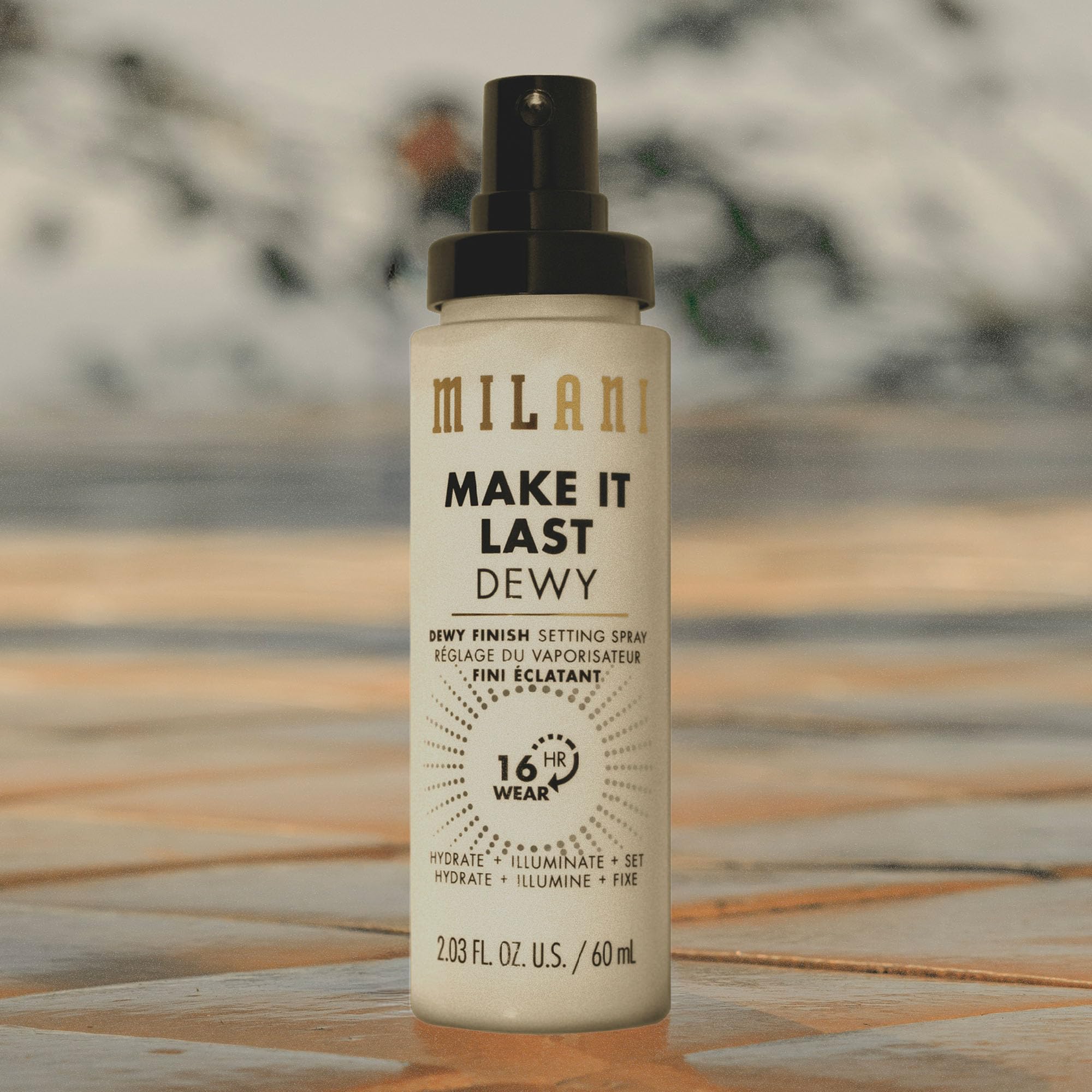 Milani bottle staged with makeup showing compatibility and finishing benefit