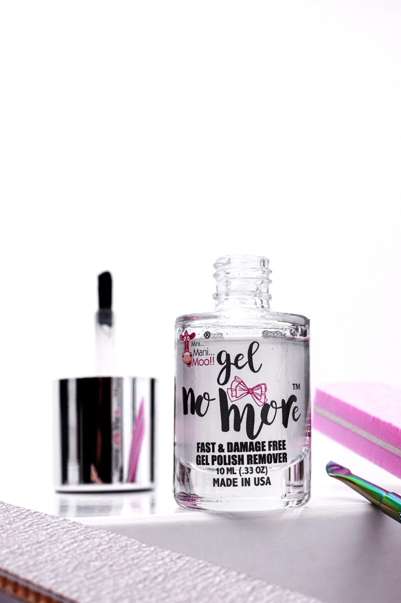 MINI MANI MOO bottle beside a coin showing size for travel convenience