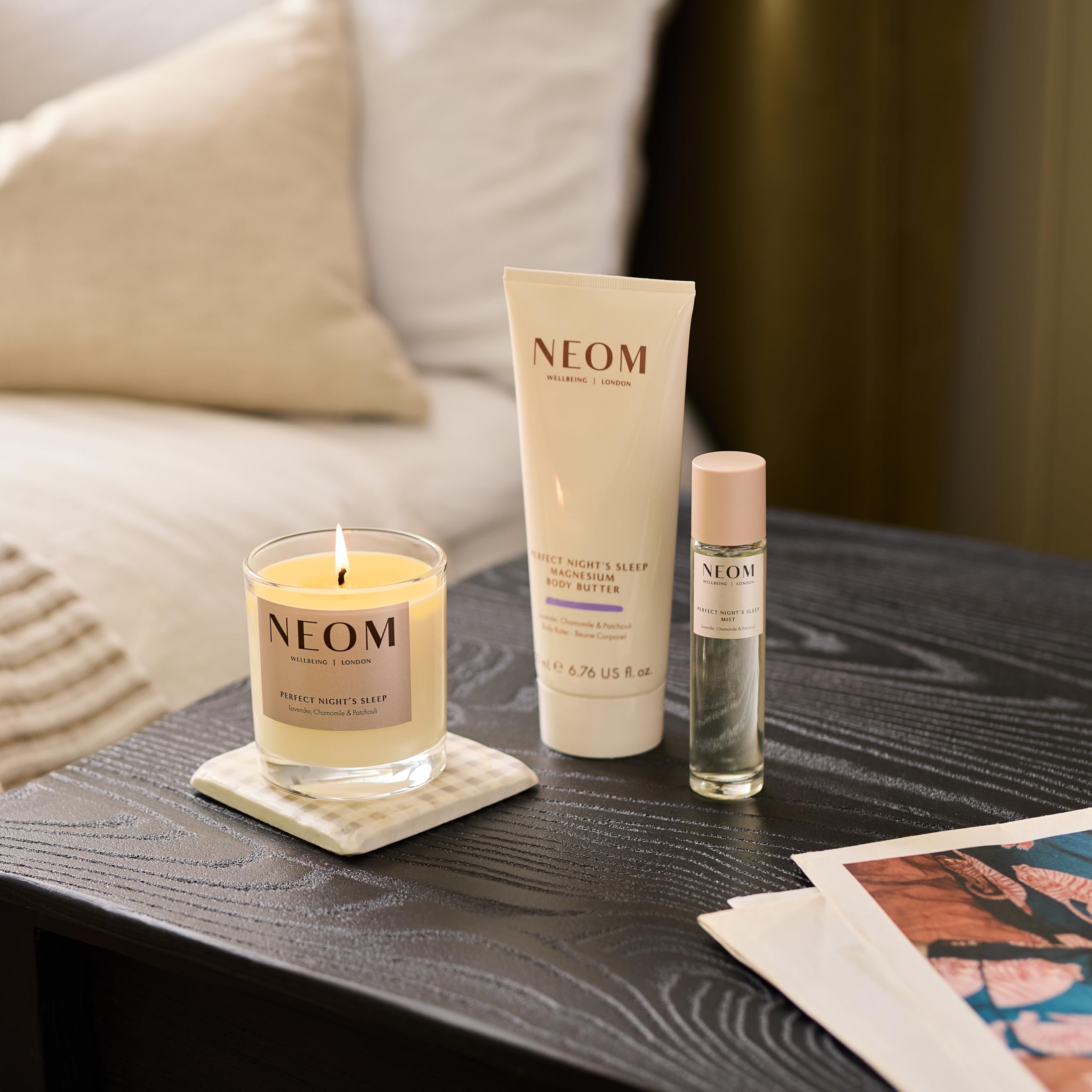 Neom body butter beside everyday objects displaying 200ml size for generous nightly use