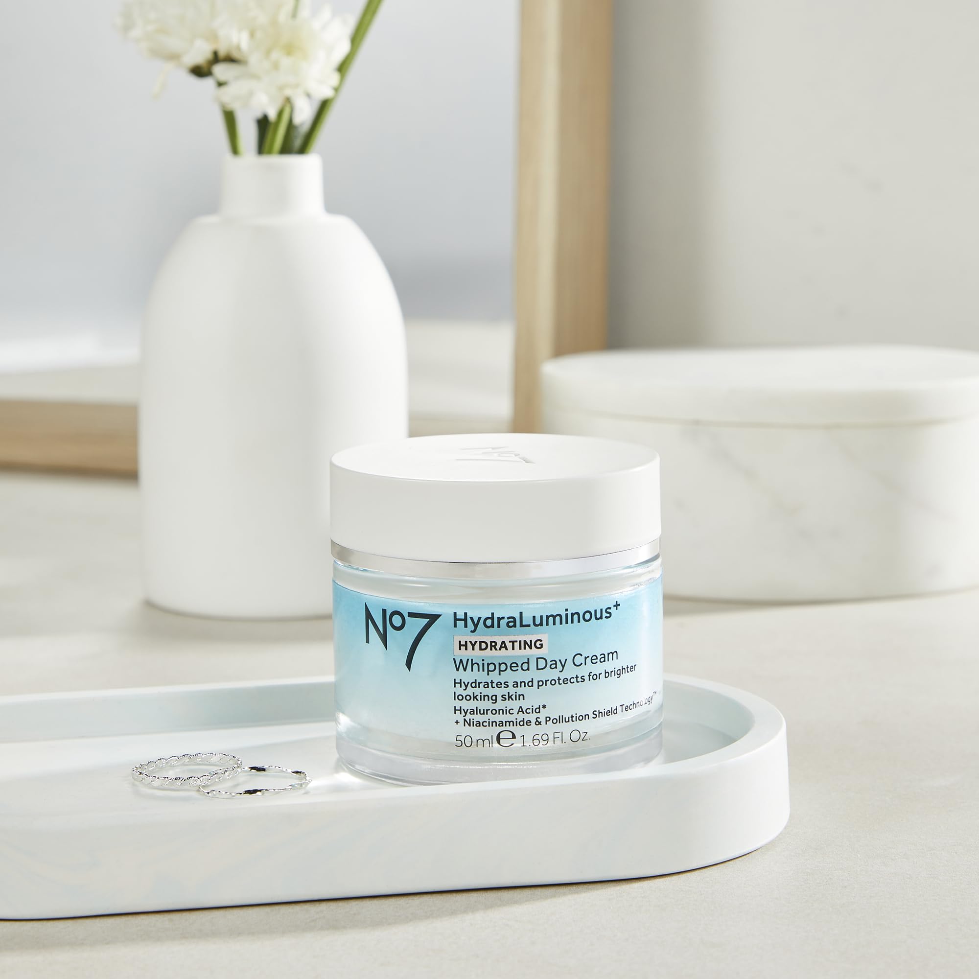 No7 hydraluminous+ next to ruler showing 1.69 fl oz size for travel-friendly convenience