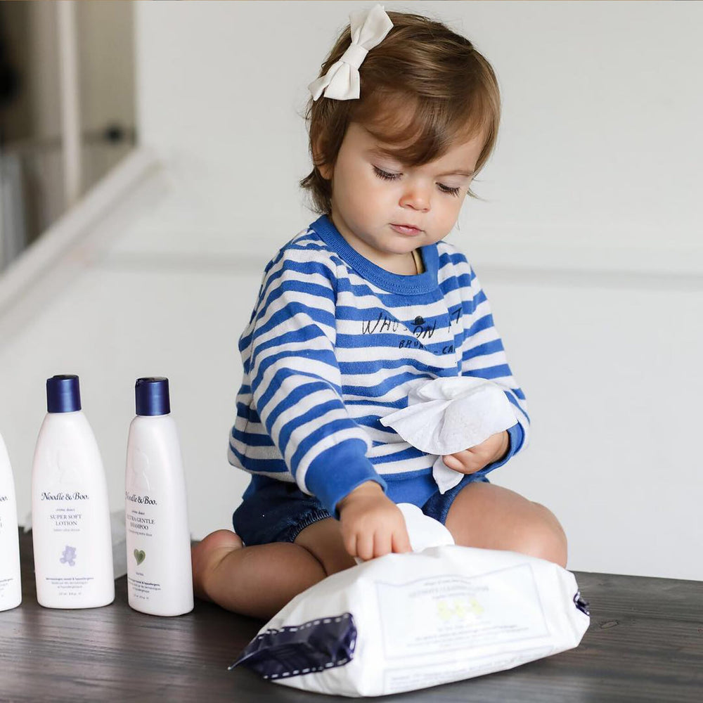 Caregiver using Noodle & Boo wipes at diaper change for gentle cleansing