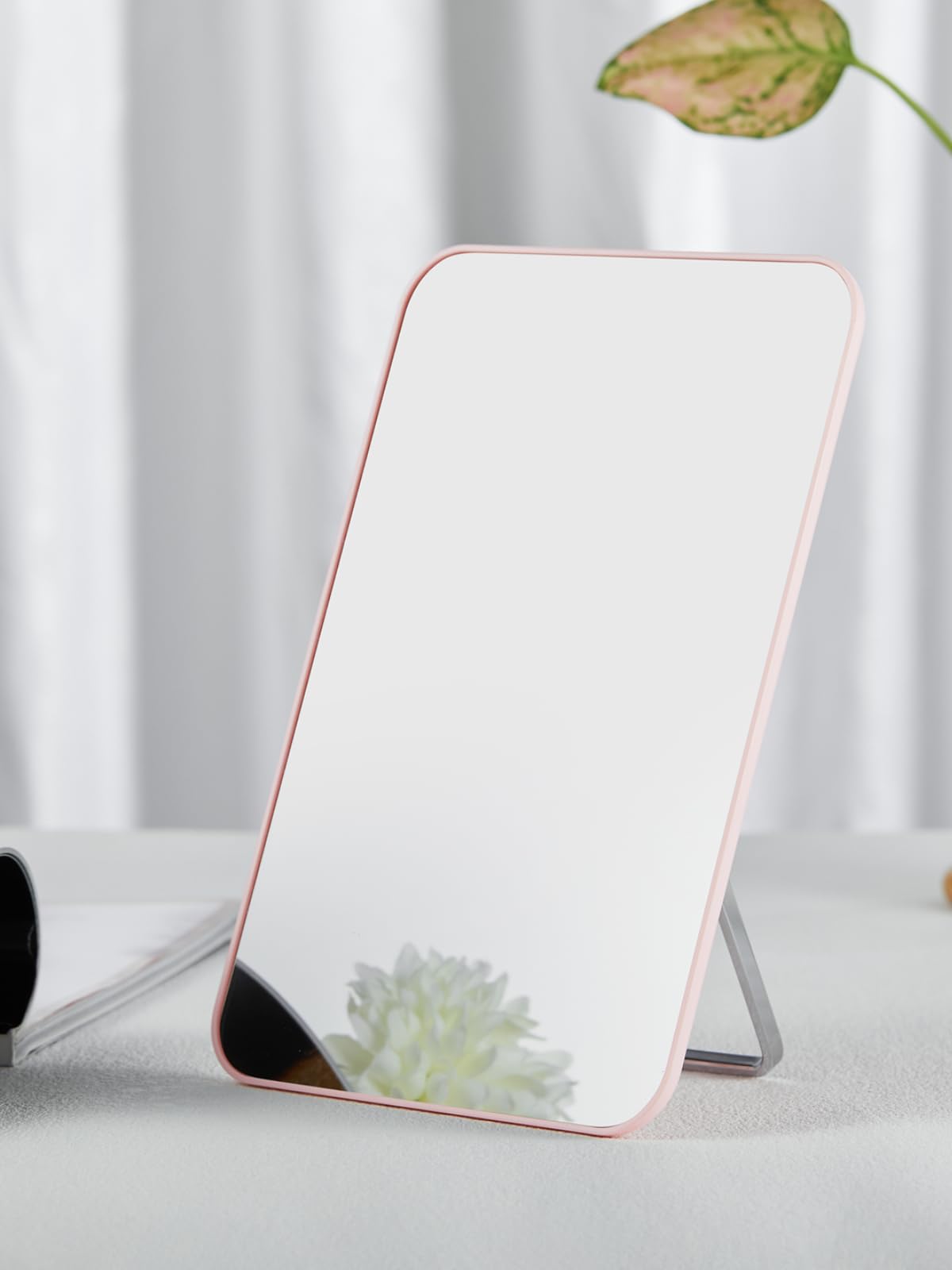 OMIRO pink mirror held in hand to show 10x7 size and portable convenience for travel and desks