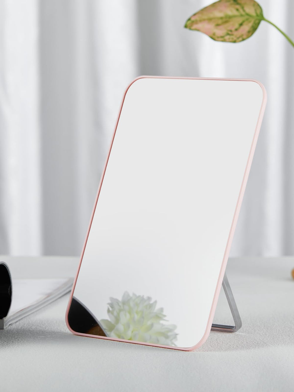 OMIRO pink mirror held in hand to show 10x7 size and portable convenience for travel and desks