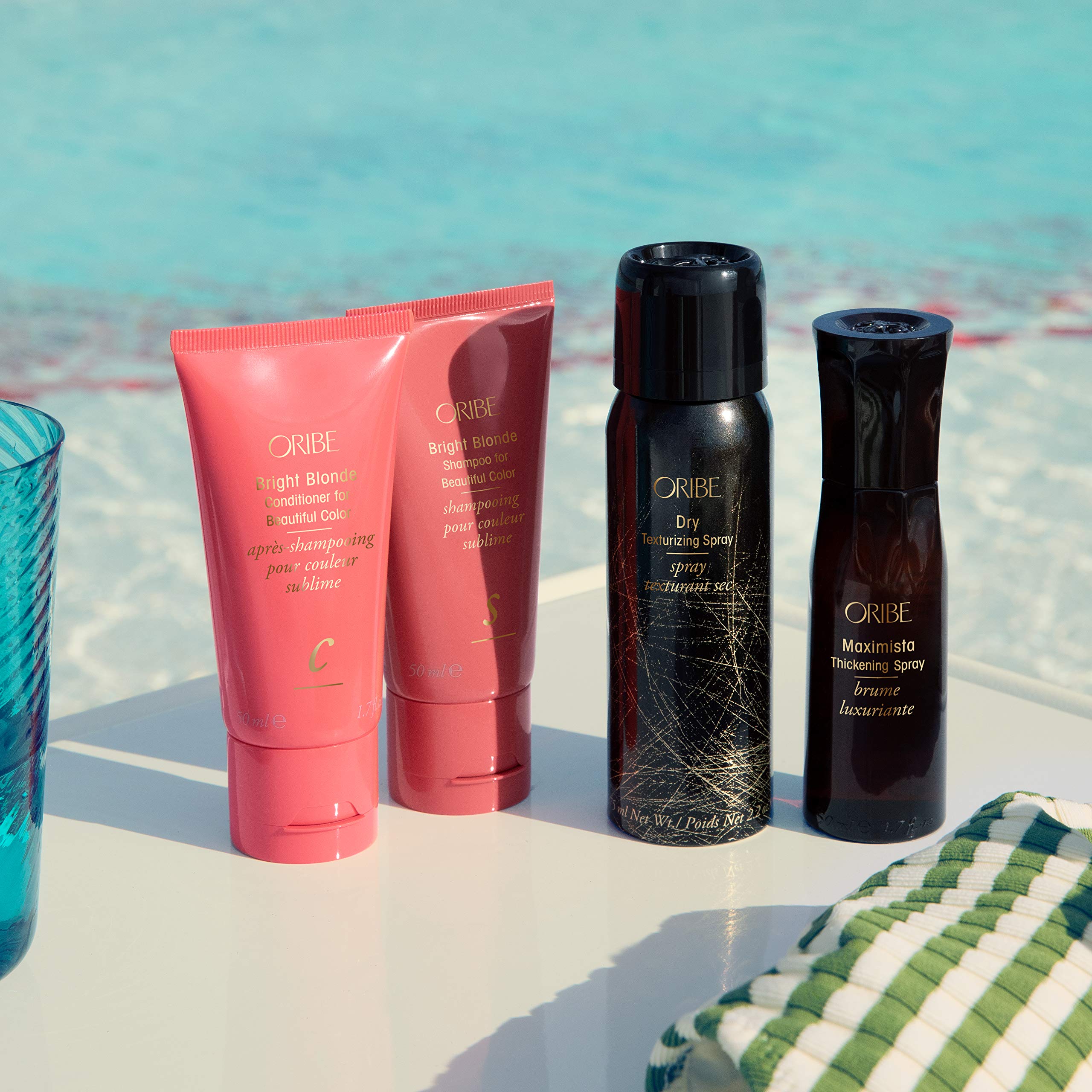 Oribe Bright Blonde Conditioner being applied to blonde hair mid-lengths demonstrating detangling and toning benefit