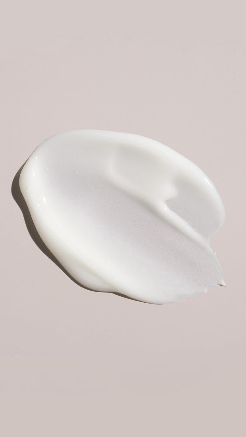 Oribe conditioner applied to damp hair in hand demonstrating easy distribution and detangling benefit