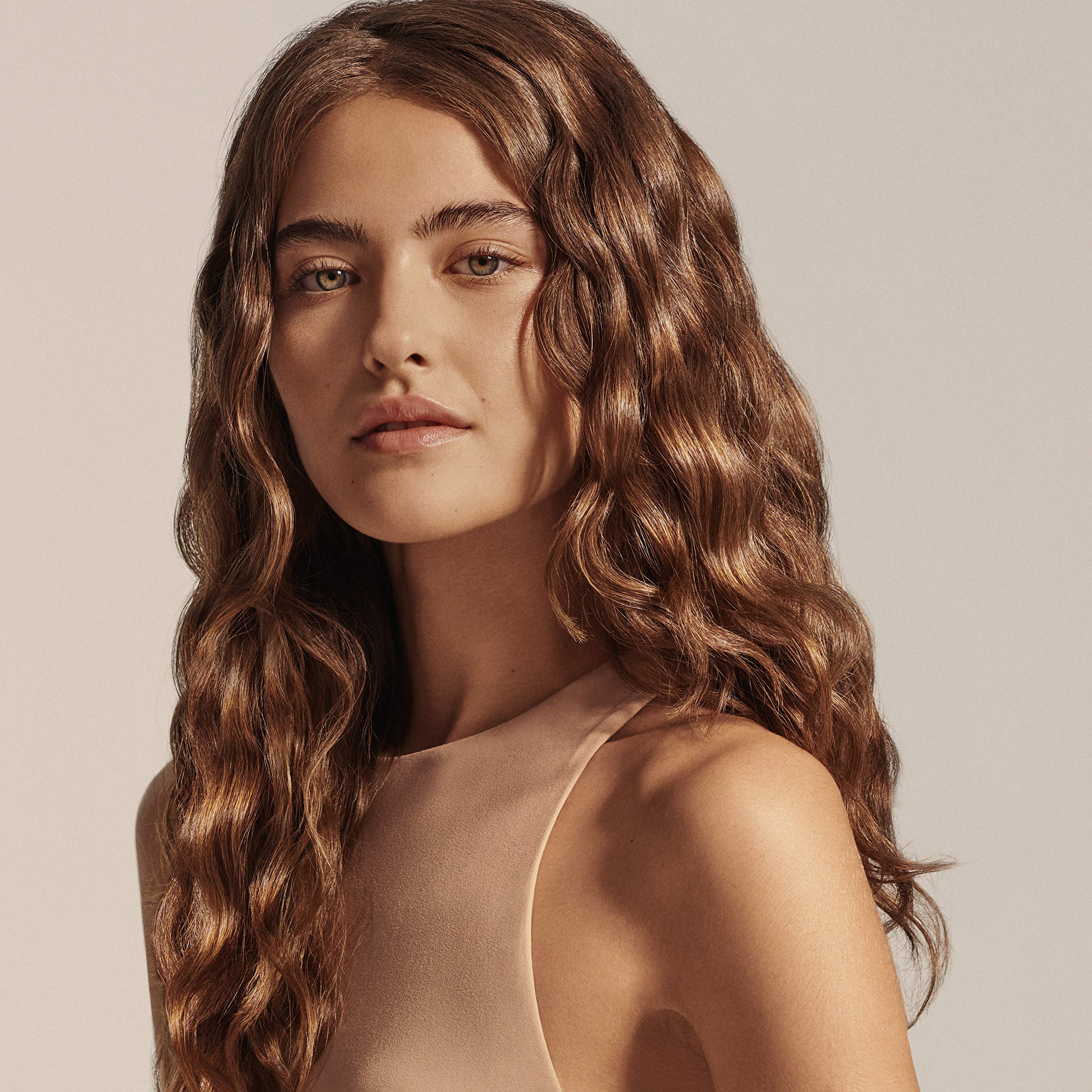 Oribe oil used before styling with flat iron showing heat protection benefit