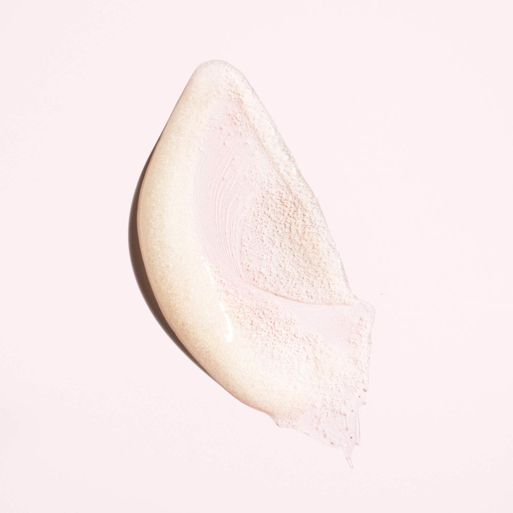 Oribe in-use scalp massage with hands working scrub into roots, showing clarifying benefit