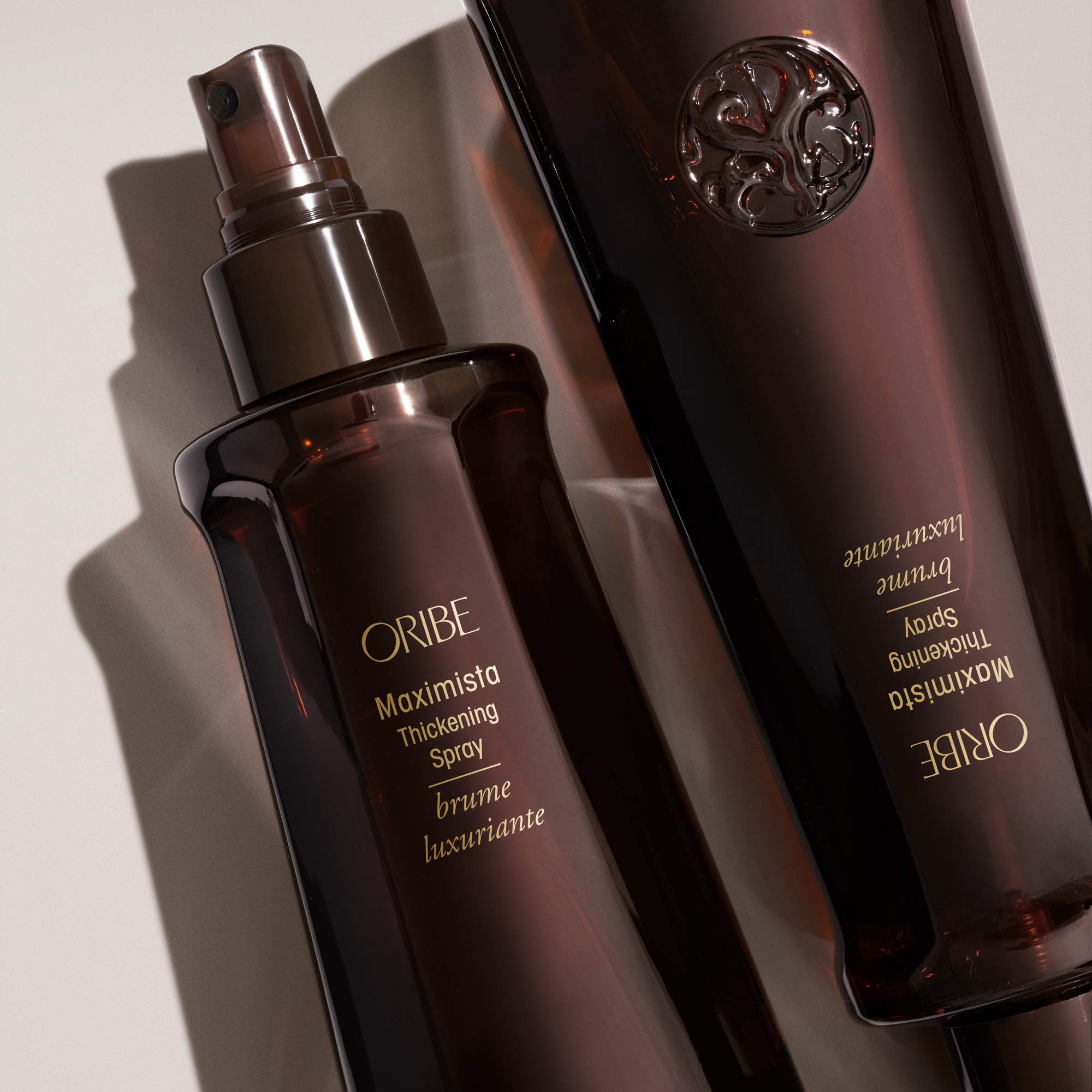 Oribe Maximista 6.8oz in hand showing scale and travel-ready size