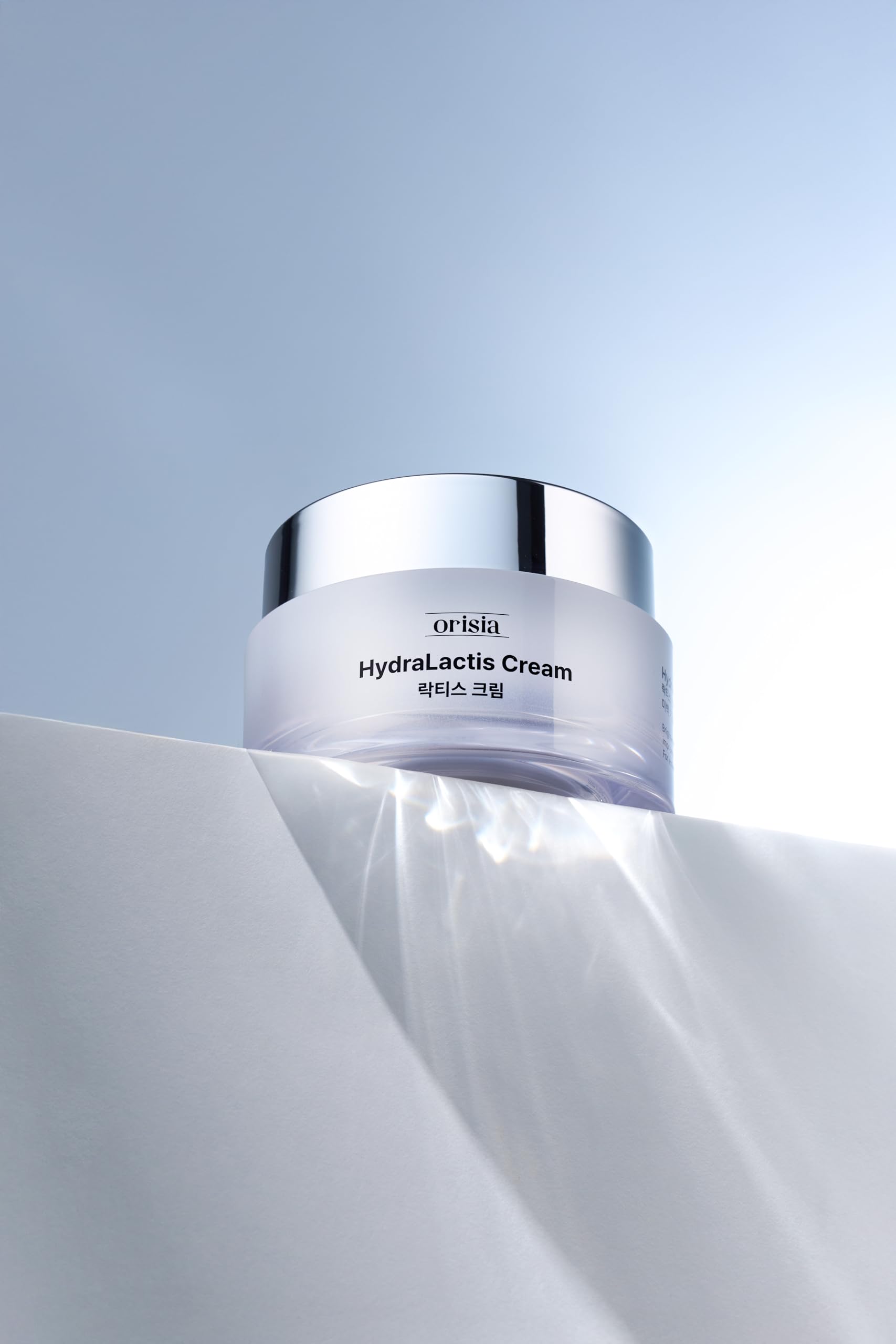ORISIA HydraLactis being applied to hand showing soft hydrated skin benefit