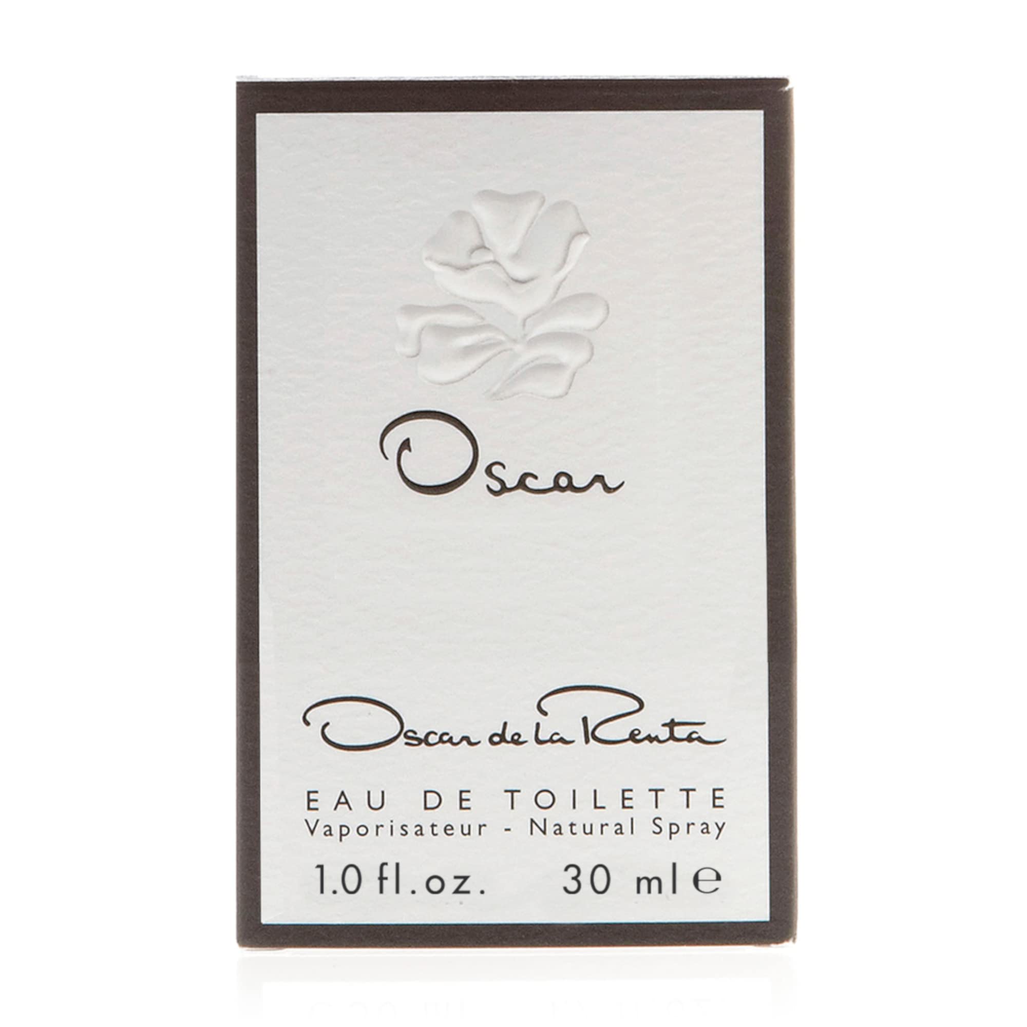 Oscar de la Renta bottle on wooden table ambient setting suggesting warm woods