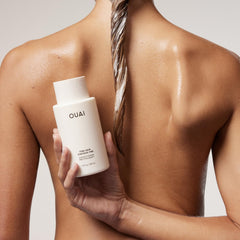 OUAI applying conditioner to mid-lengths demonstrating added volume